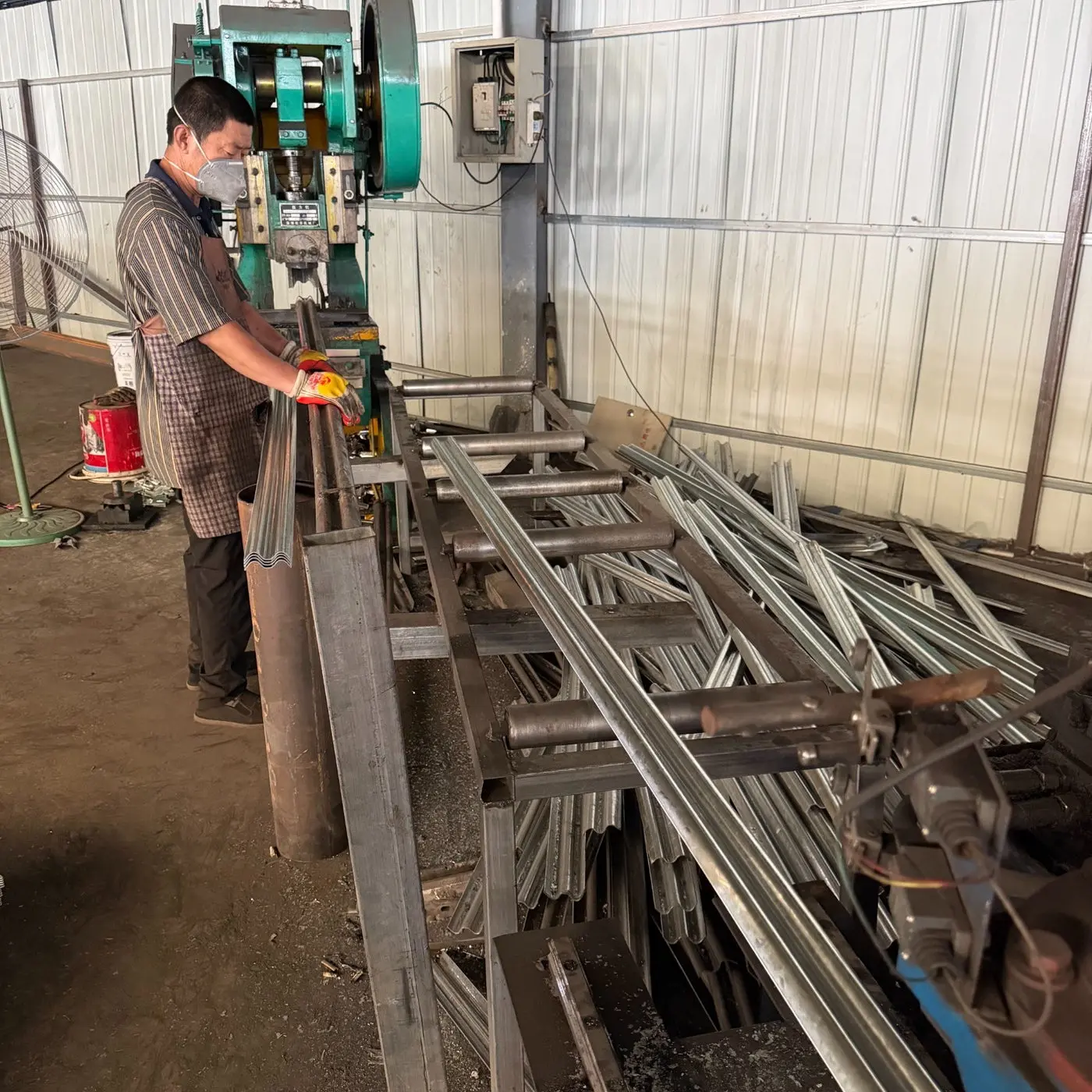 KUNYU production team member operating a steel post forming line