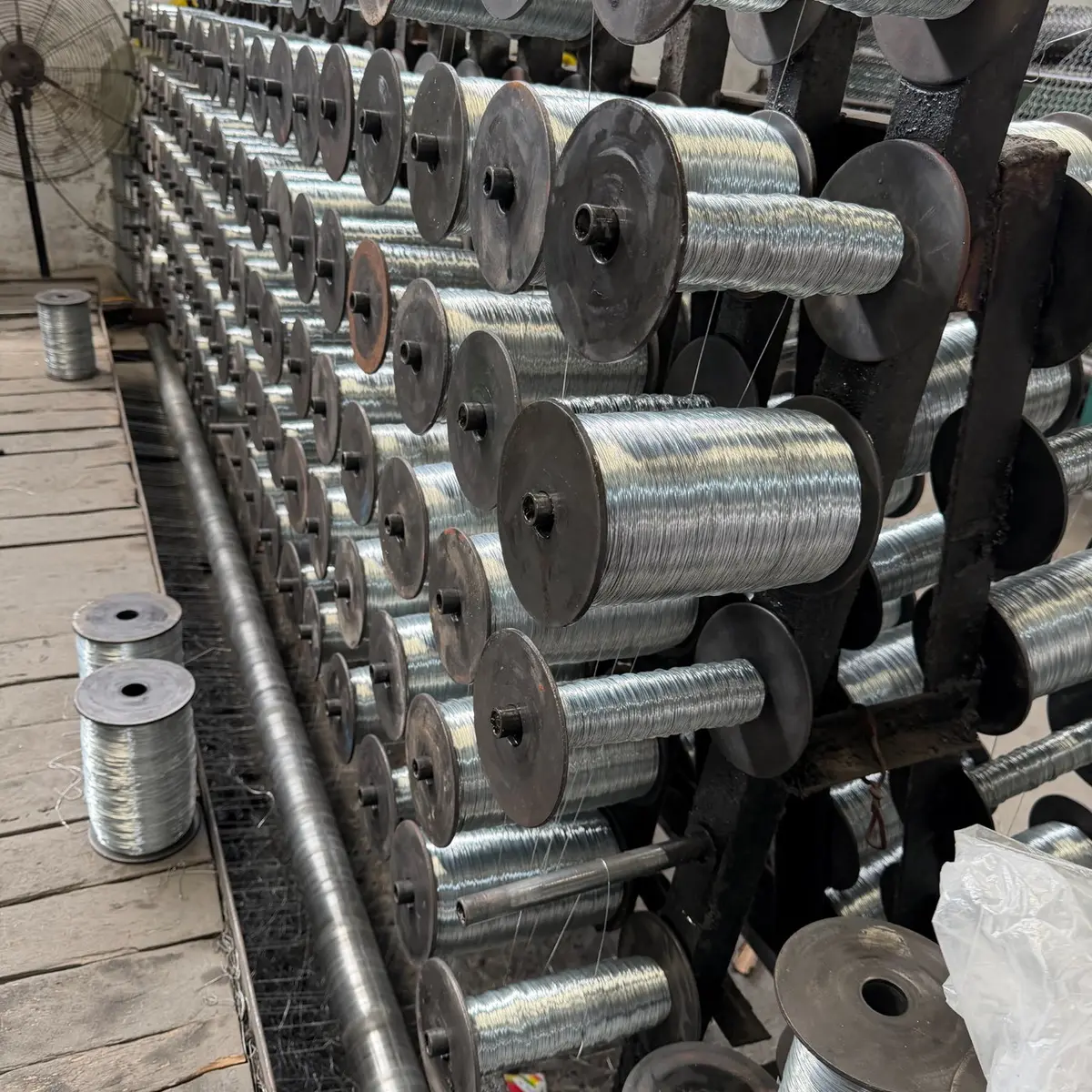 Wire spools feeding KUNYU fencing production equipment