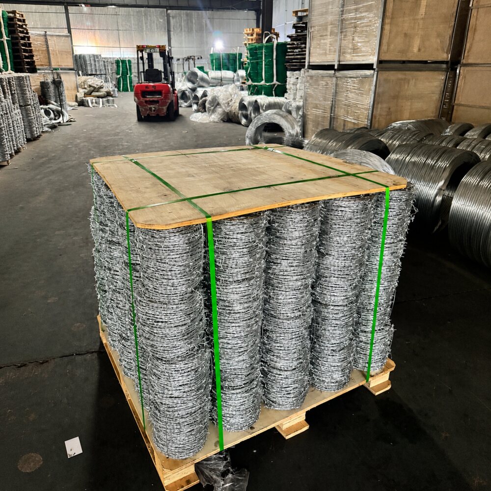 Galvanized 4-point barbed wire coils secured on a pallet for export packing