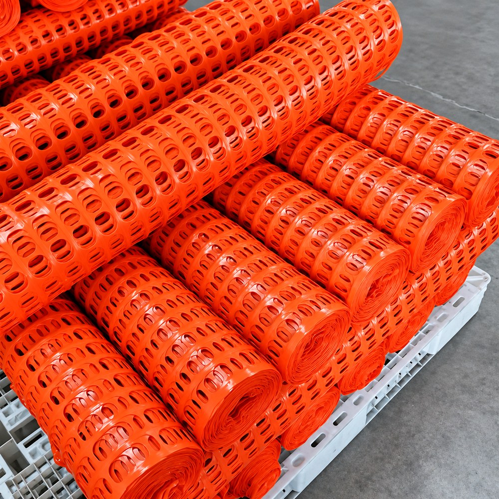 Orange plastic fence rolls packed together
